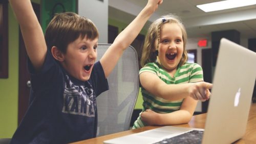 Kinder am Notebook freuen sich