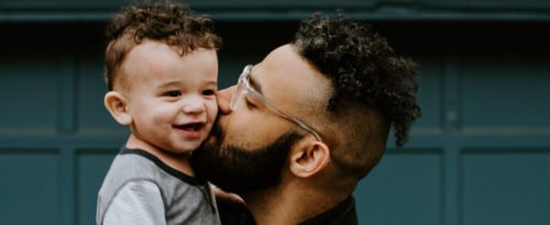 Vater/Mann küsst sein Kind