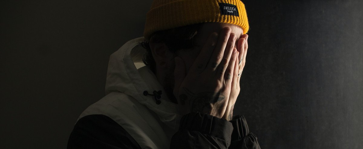 Junge hält Hände beschämt vor Gesicht