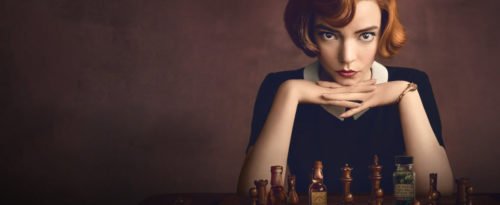 Die Protagonisten sitzt vor einem Schachbrett und blickt den Zuschauer direkt an