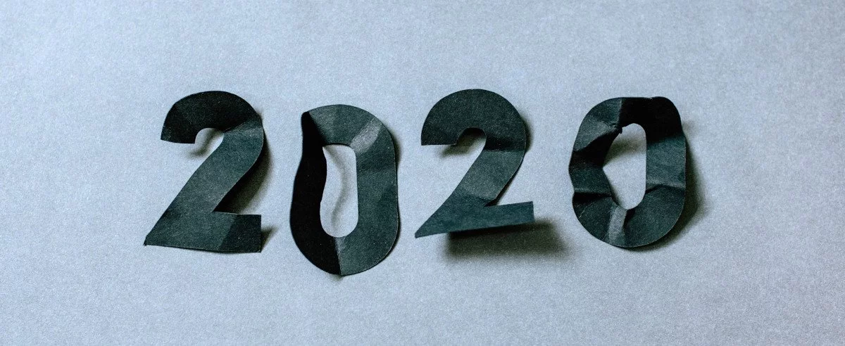 Die Zahlen "2020" in schwarzem, zerknitterten Papier auf weißem Untergrund