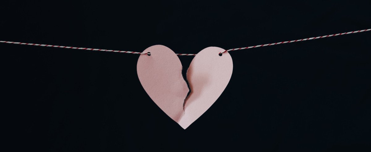 Ein zerrissenes Papierherz auf einem Faden