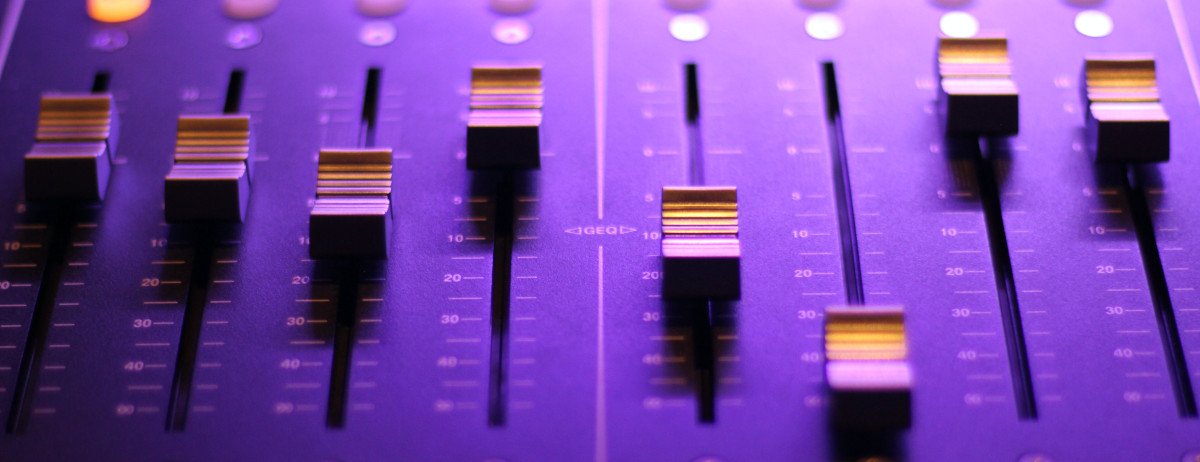 Ein Mischpult in violetter Farbe mit Reglern im Fokus