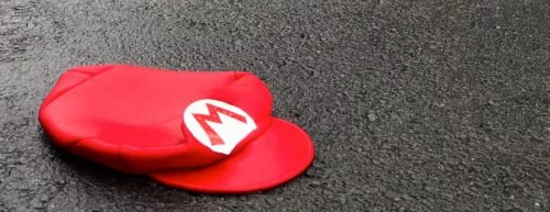 eine rote Mütze von Mario, die auf der grauen Straße liegt