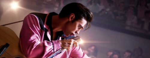 Elvis Presley, der sich das Mikrofon an den Mund hält